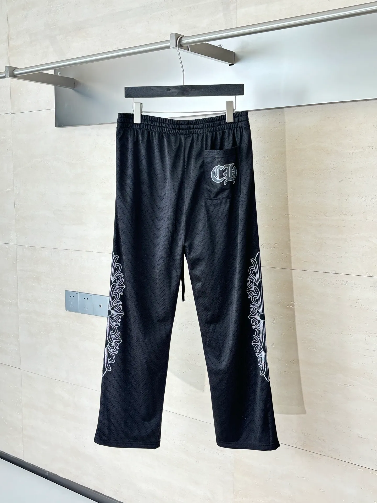 P340 Chrome Heart*/Chrome Heart Sanskrit mesh ice hockey suit straight trousers. The original version was purchased for 15,989 and developed. The fabric is made of custom weaving and dyeing technology. It is made of selected black mesh fabric, showing a unique sports style. The fabric has been specially treated to provide excellent breathability and comfort while maintaining a crisp and structured look. The double-layer design structure enhances the overall texture and makes the wearing experience more three-dimensional and full. The brand's iconic patterns are printed in many places, and high-precision printing technology is used to ensure that the patterns are clear and sharp. The silver printing has a glitter effect, showing charming luster changes under different lights. All printings undergo strict color difference control to ensure accurate color reproduction. The silver-plated pattern design on the sleeve arms is particularly eye-catching, showing the brand's consistent dark luxury style. In terms of details, the latest custom-woven labels are used, and the workmanship is exquisite. The overall shape is designed for both men and women, with both fashion and practicality. This T-shirt perfectly combines sports elements with high fashion craftsmanship, making it the brand's iconic street style item.  Size：S/M/L